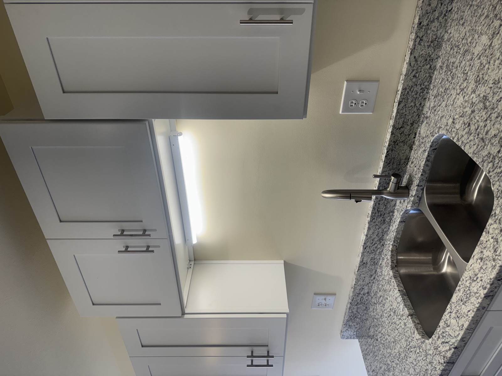 Kitchen sink and cabinets with granite countertops at SouthTowne Apartments